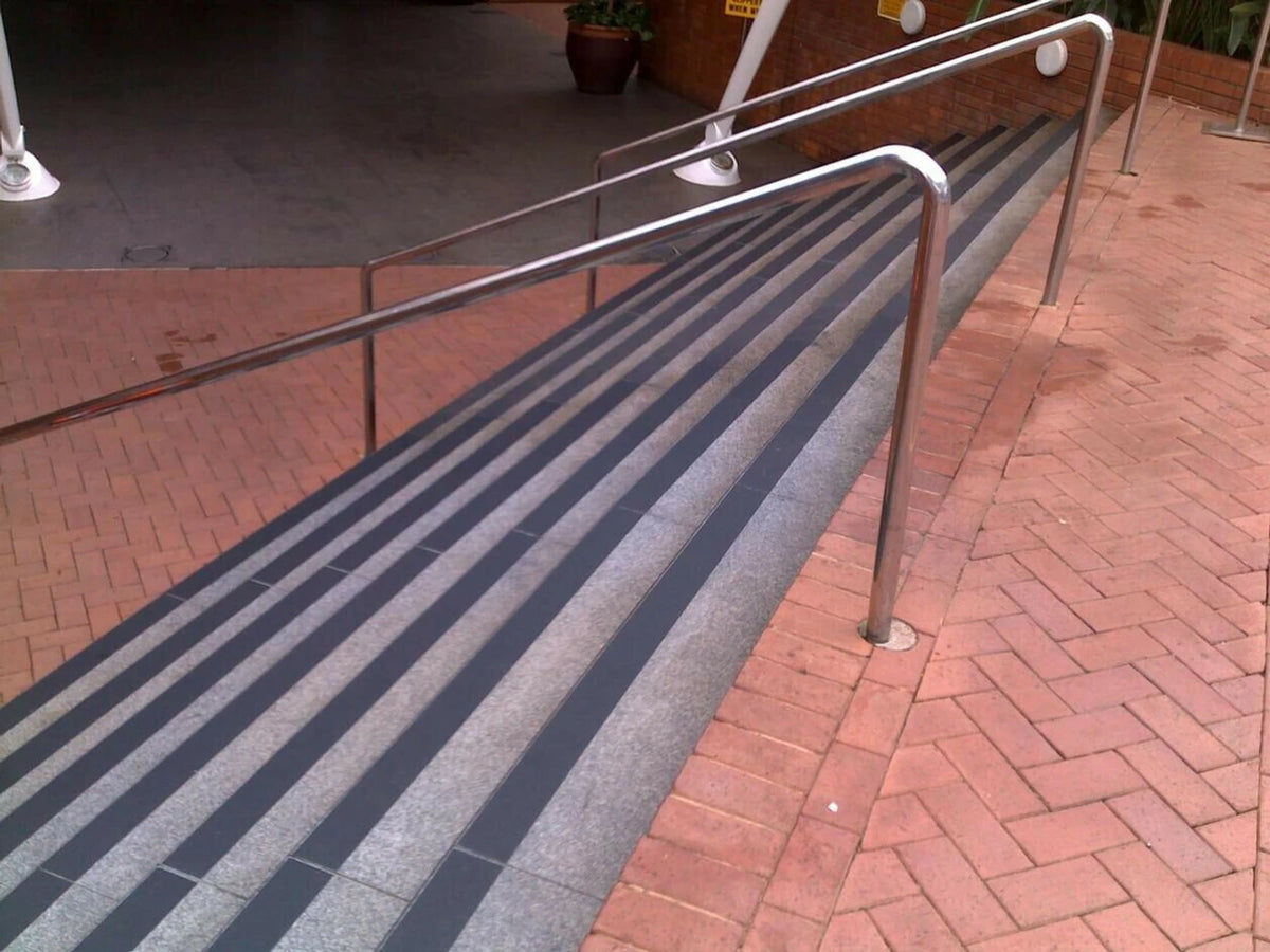Anti-Slip Safety Tape applied on outdoor ramp with railings - non-slip grip strips for safety